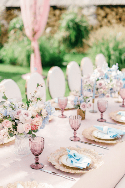 spring bridal shower table setting for a garden or tea party, colored glasswear and pink roses decorate the table