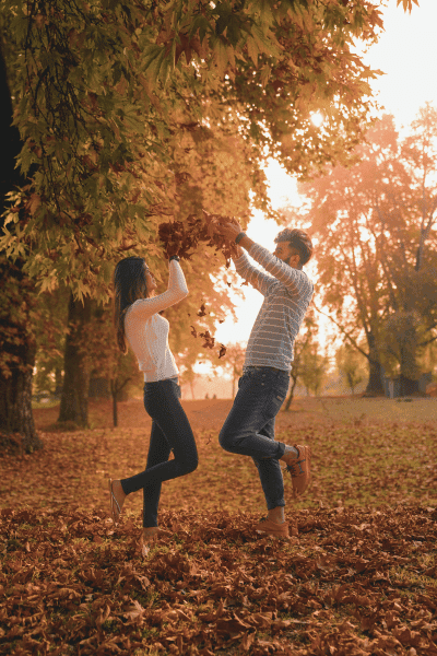 playing with leaves fall engagement photoshoot ideas